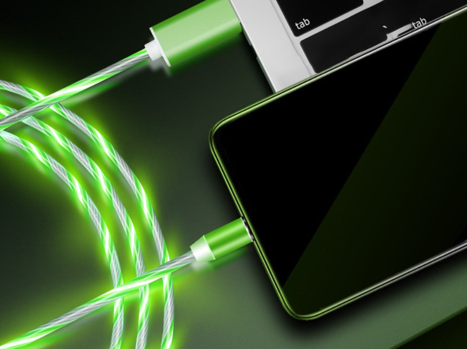 A glowing green Gadgets Link Flowing Light Magnetic Streamer Data Line Cable connects a smartphone to a laptop keyboard, emitting bright green light. The cable is compatible with Apple, Android, and Type-C devices for a modern tech look.